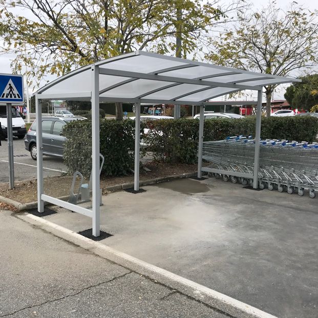 Abri vélo ALTAO Curve sur un parking de zone commerciale