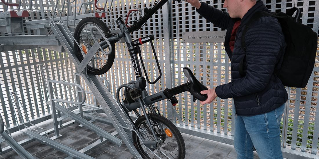 cycliste rangeant son vélo sur rack de stationnement Optima