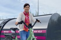 portrait de Corinne Verdier devant un box vélo pour l'article de l'Essor 42