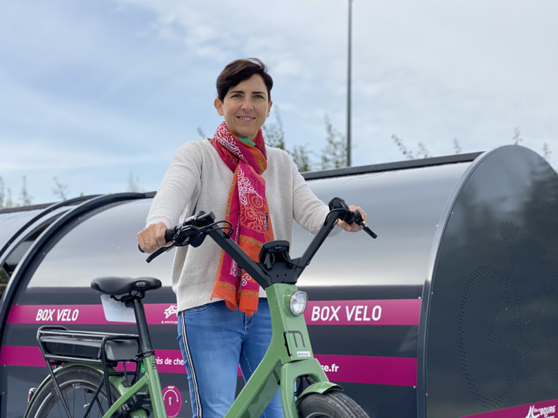 portrait de Corinne Verdier devant un box vélo pour l'article de l'Essor 42