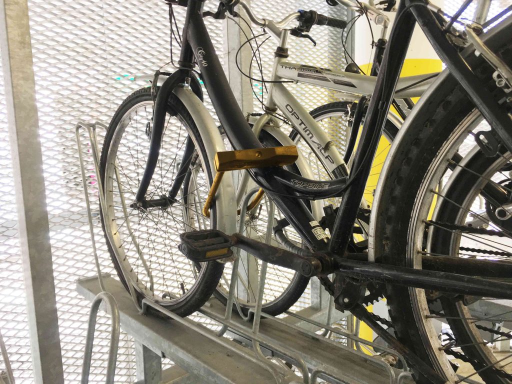 Vélo attaché par un antivol au cadre à la roue et à l'arceau de l'Optima V10
