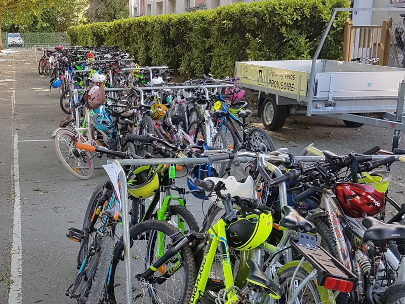 Racks ALTAO® Mobiles remplis devant une école grnobloise à l'occasion des concours de école pour promouvoir le vélo auprès des plus jeunes