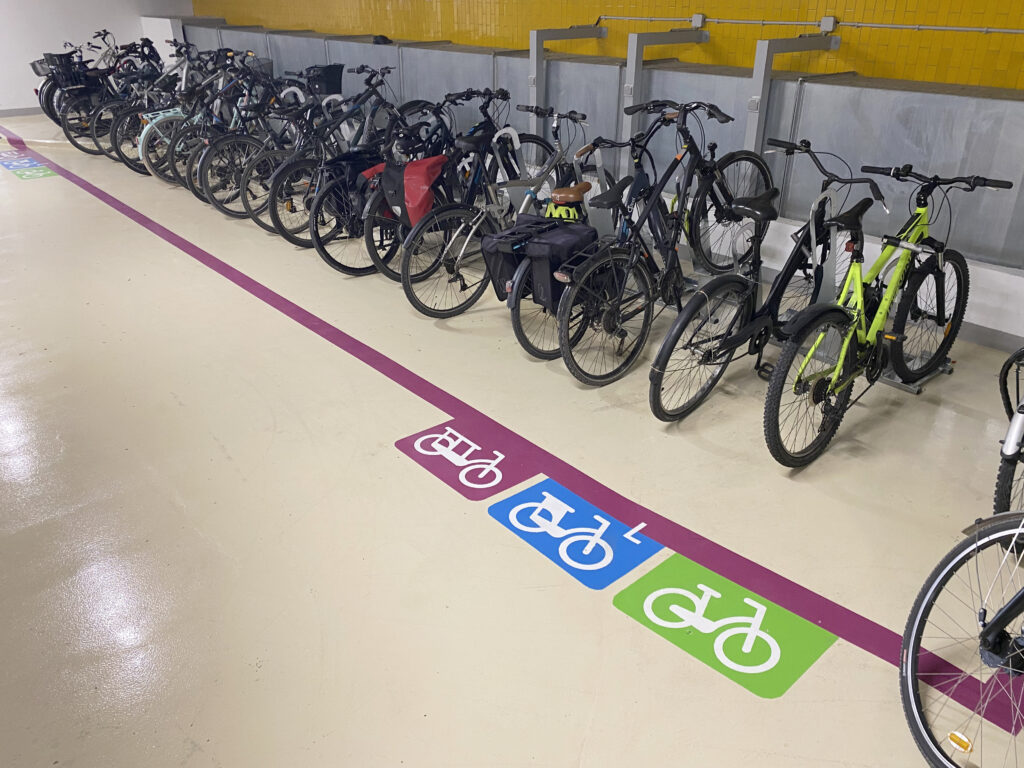 vélos stationnés sur les arceaux ALTAO® Parco avec 3 prises de recharge électrique pour les VAE dans l'espace en libre accès