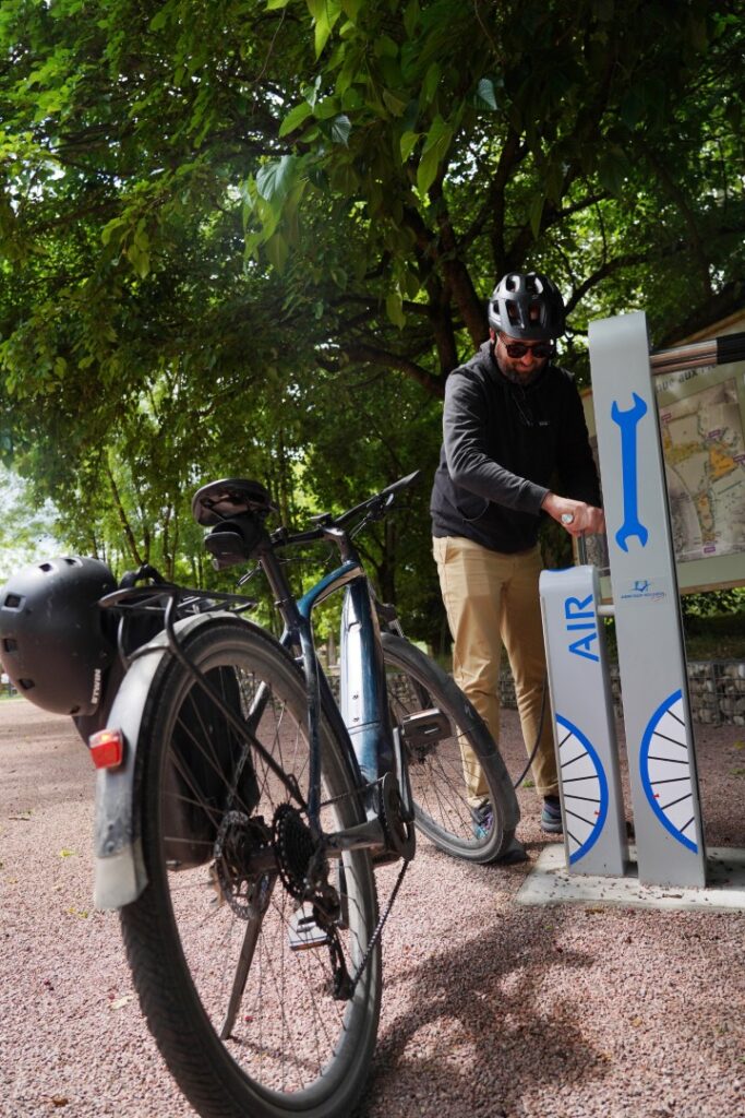 Cycliste gonflant son vélo grâce à une station ALTAO® Fix’Air en libre-service.