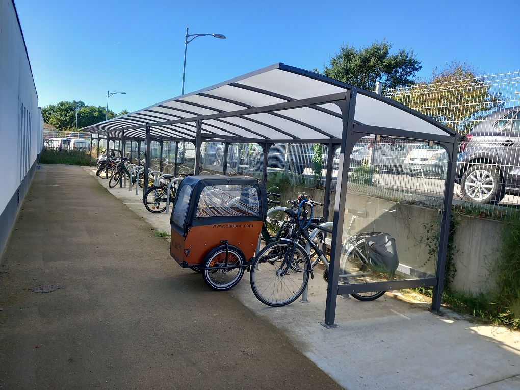 Vélos stationnés sous un abri ALTAO® Curve sur un site de travail